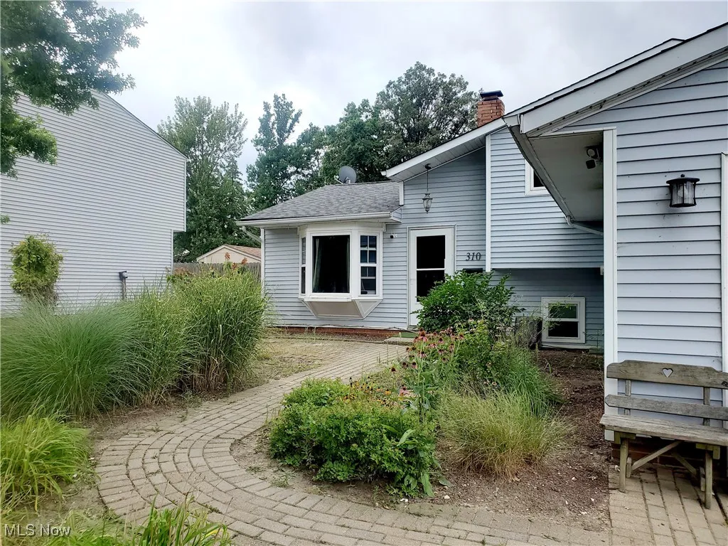 Back of property featuring a chimney and a shingled roof