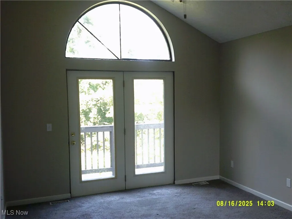 Doorway with carpet and lofted ceiling