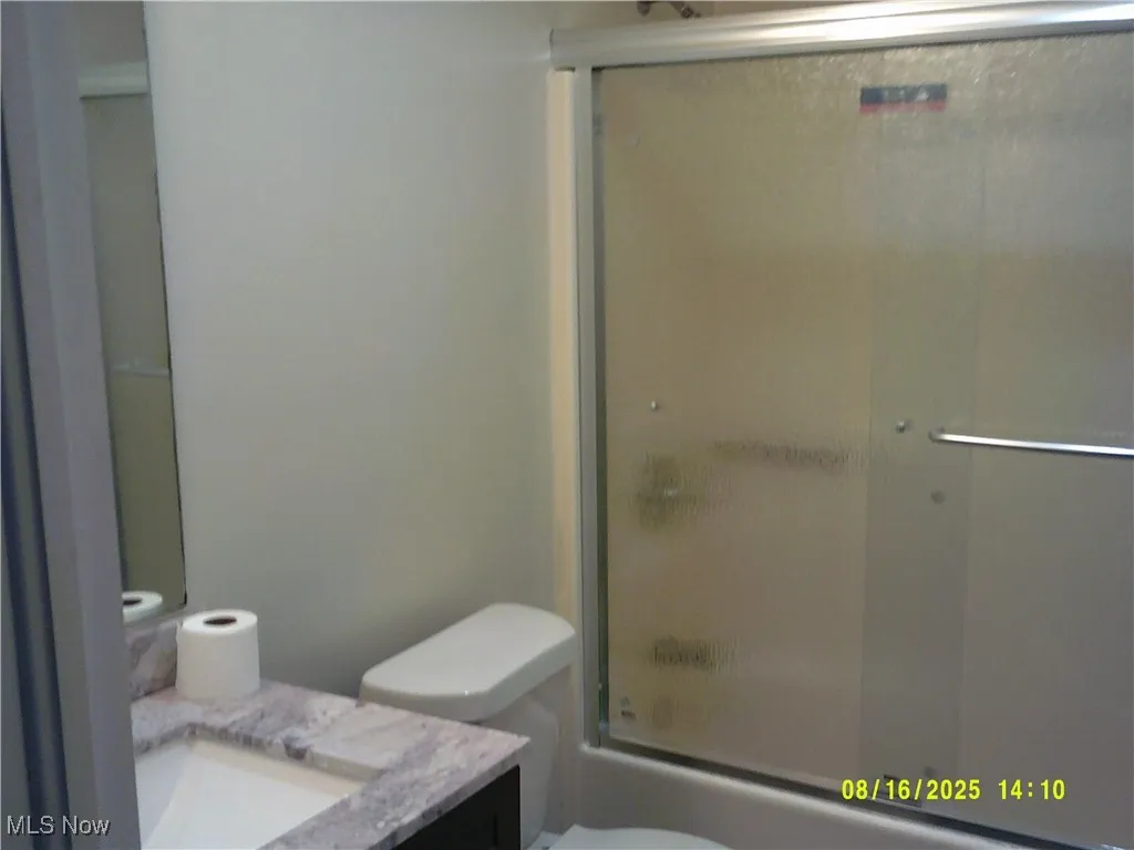 Full bath featuring vanity and enclosed tub / shower combo