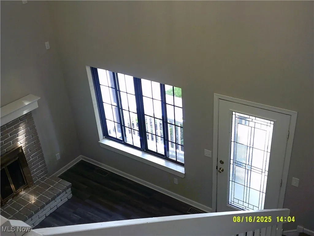 Unfurnished living room featuring a fireplace and dark wood finished floors