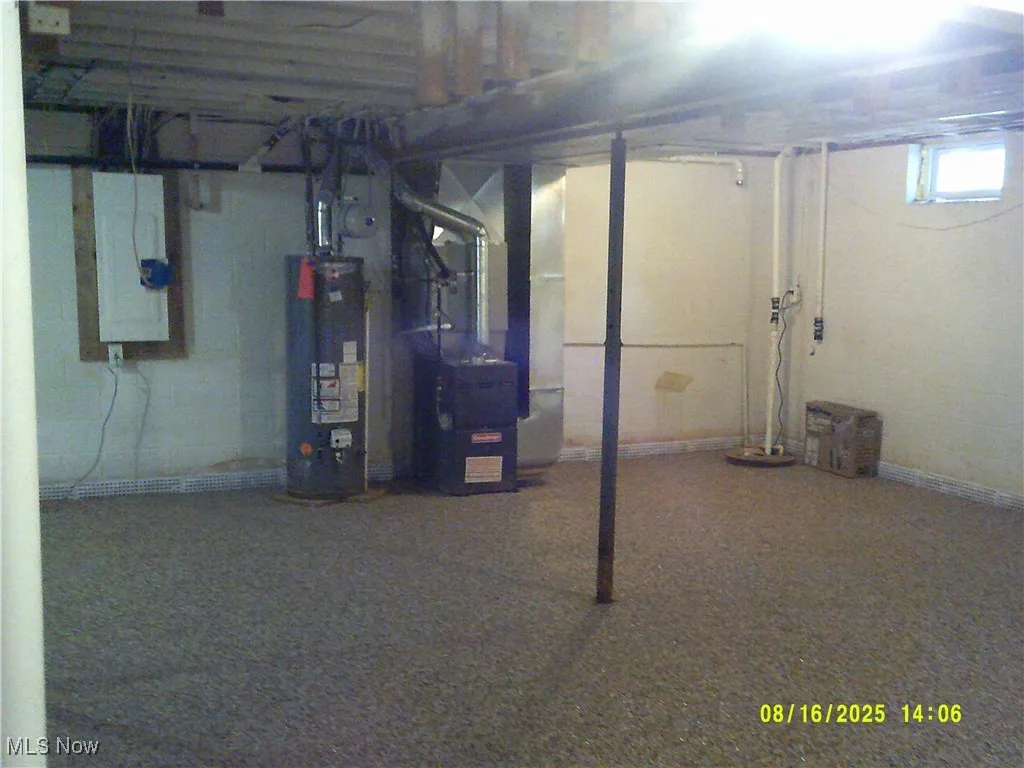 Below grade area featuring heating unit, gas water heater, and drainage system