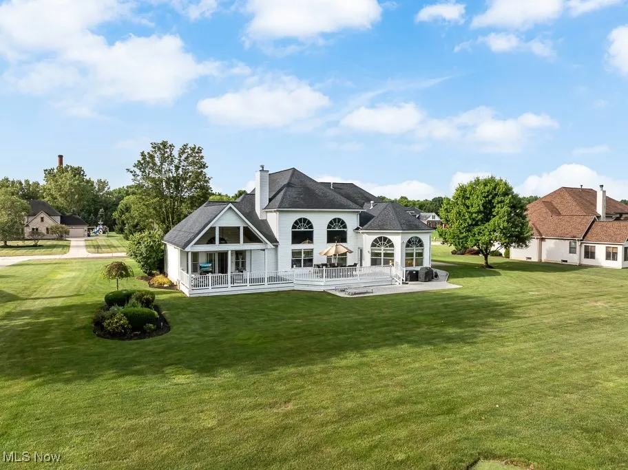 Back of house with a yard, a chimney, a patio, and a deck