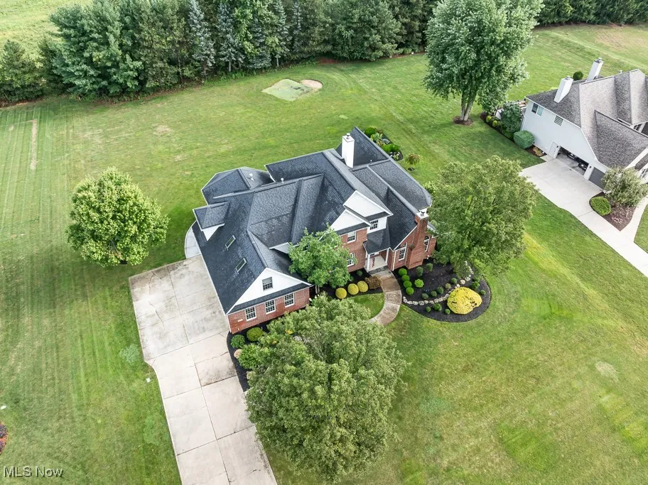 Aerial view of property and surrounding area featuring a tree filled landscape