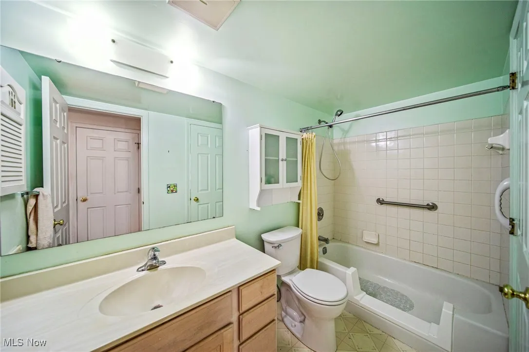 Bathroom with shower / tub combo with curtain and vanity