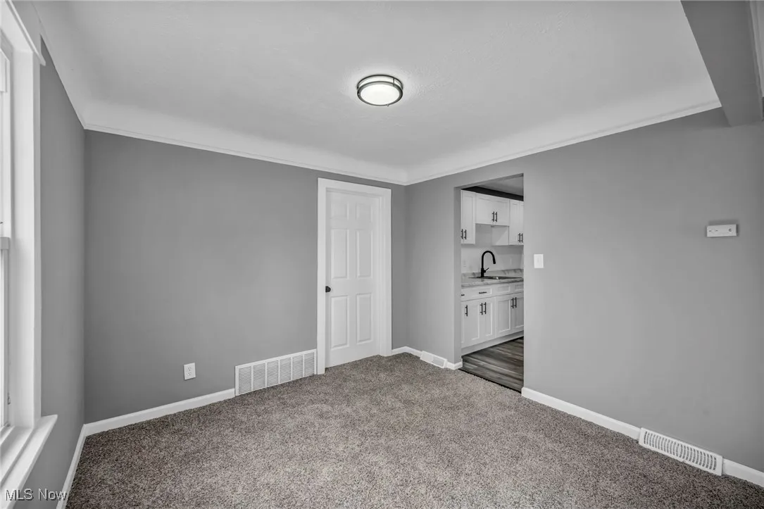 Unfurnished bedroom featuring baseboards and dark carpet