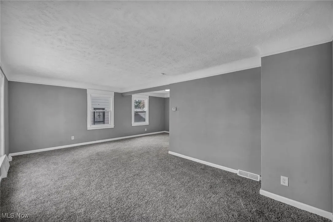 Unfurnished room featuring a textured ceiling and carpet flooring