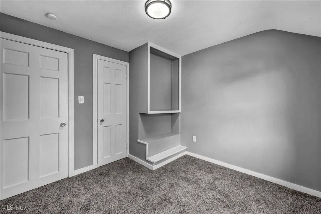 Empty room featuring carpet flooring and baseboards