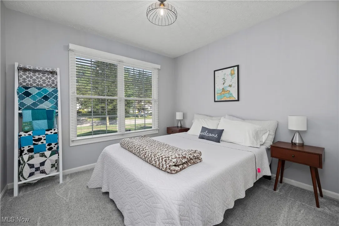 Bedroom with light carpet and a textured ceiling