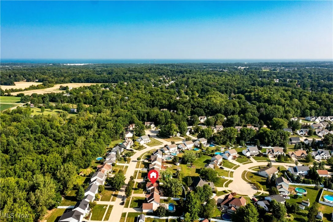 Aerial view of property and surrounding area featuring nearby suburban area