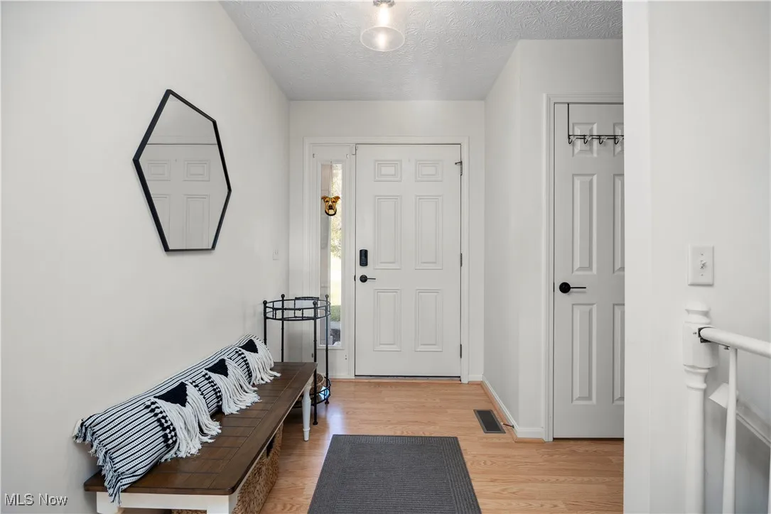 Entrance foyer featuring a textured ceiling and light wood finished floors