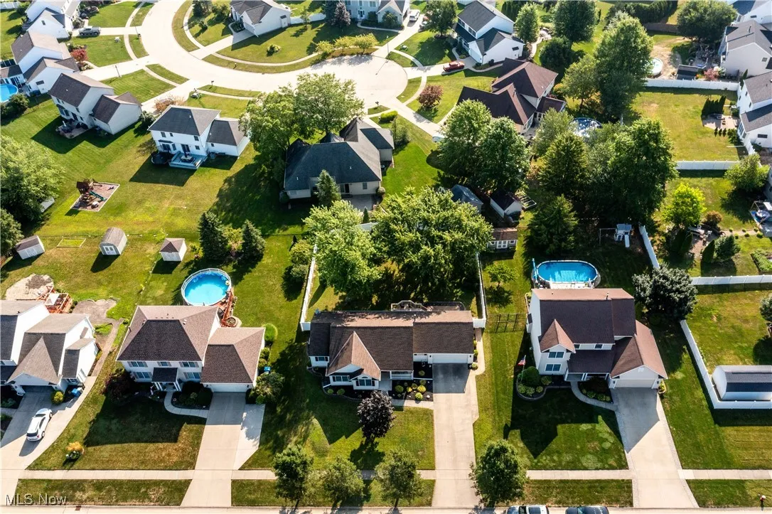 Aerial view of property and surrounding area featuring nearby suburban area