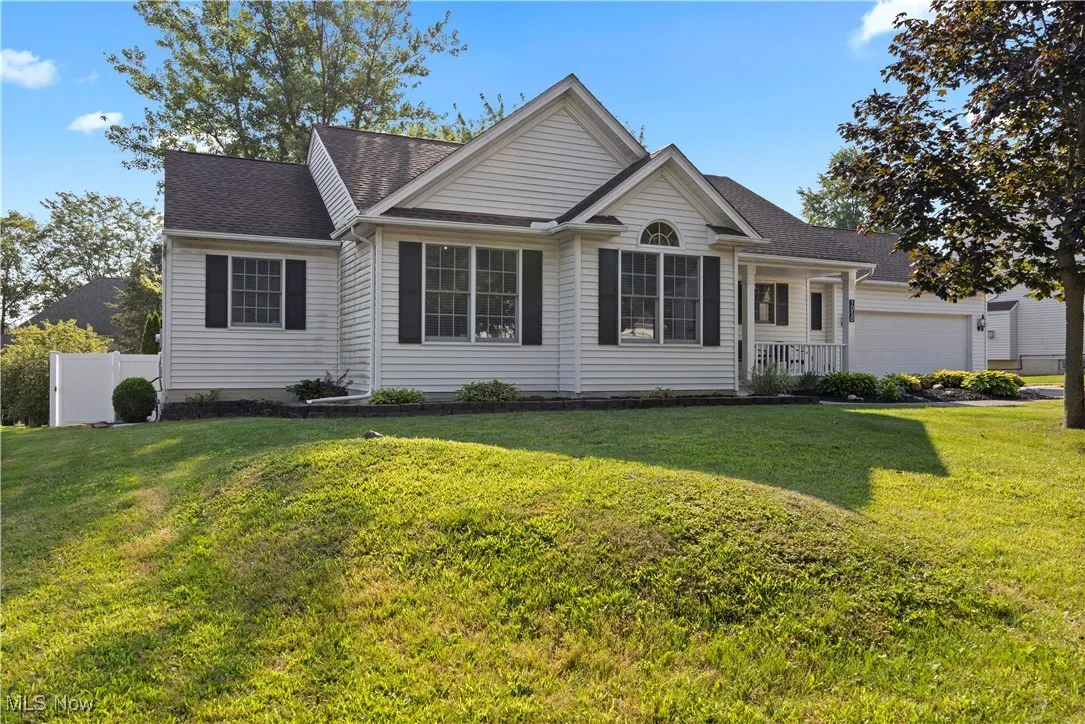 Ranch-style house with covered porch, roof with shingles, and a garage