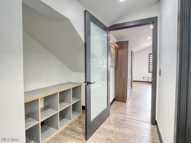Corridor featuring lofted ceiling, light wood finished floors, and recessed lighting