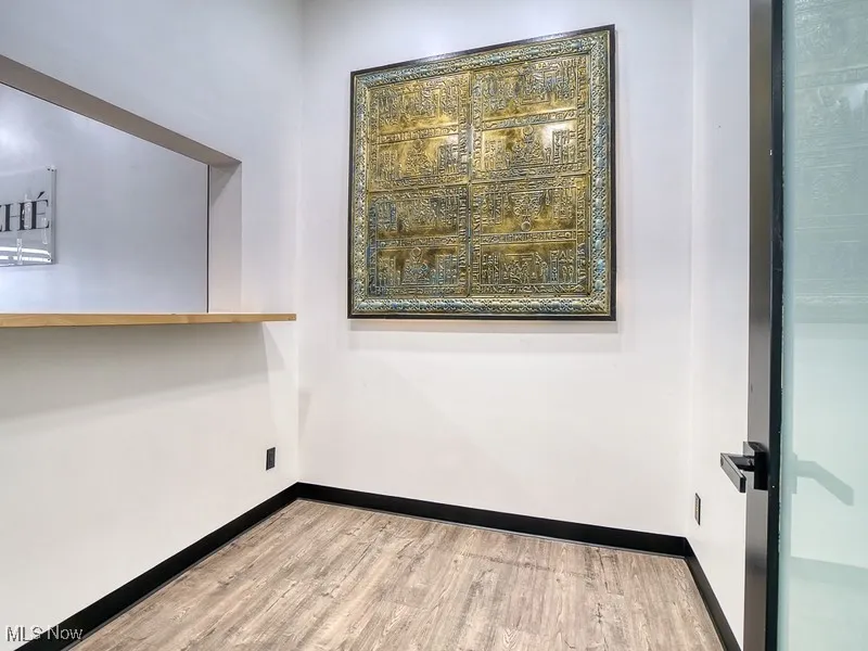 room behind reception desk featuring light wood-type flooring and baseboards