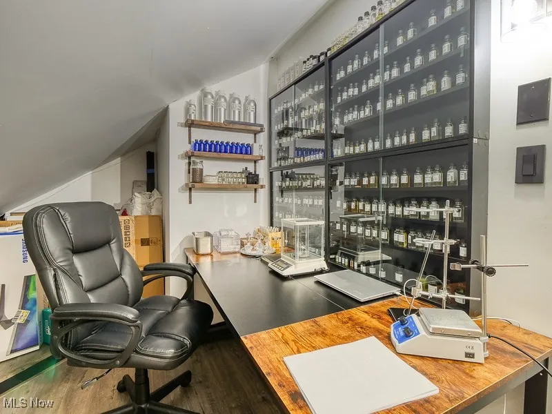 Office space with wood-like  finished floors and angled ceiling