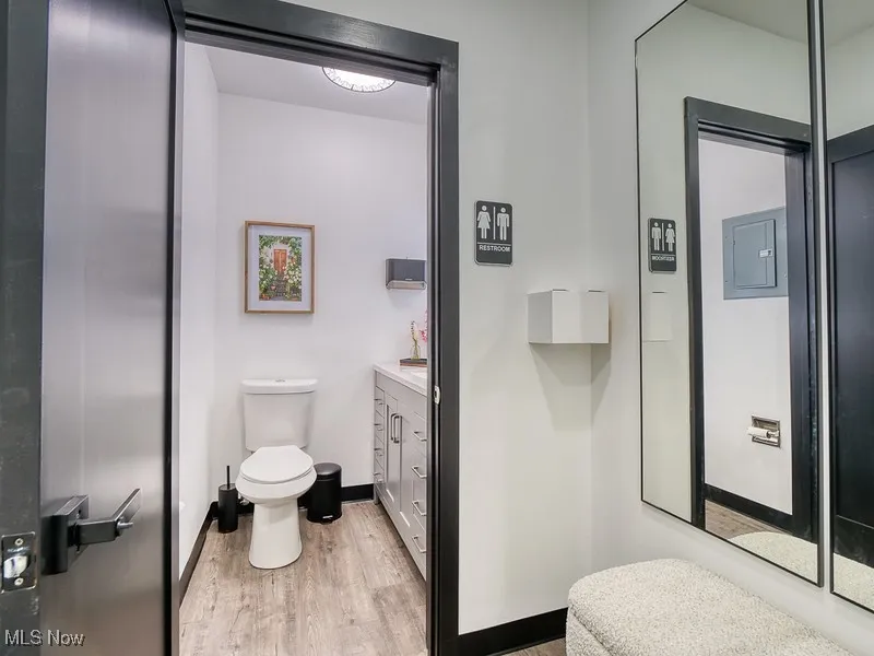 Half bathroom with vanity and light wood-type flooring, smart mirror