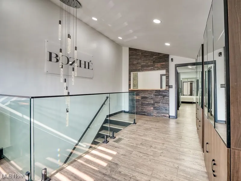  featuring lofted ceiling, light wood-style floors, recessed lighting, and a stone reception desk