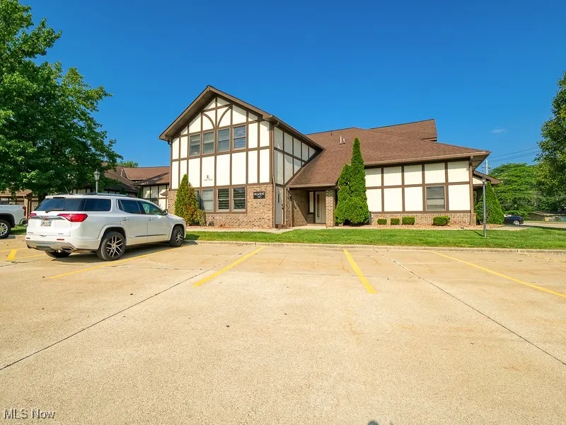 Tudor home featuring brick siding and uncovered parking