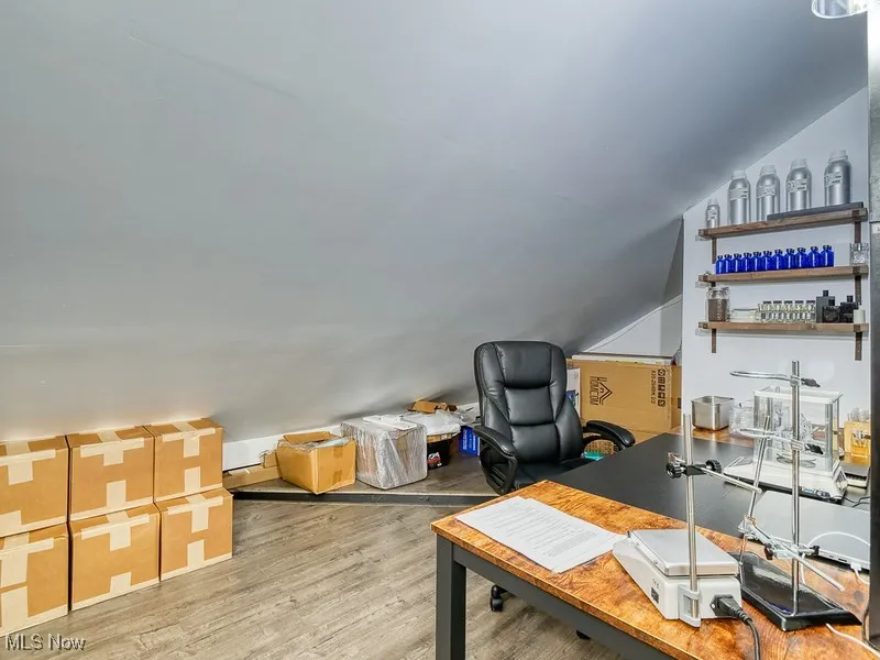 Office featuring angled ceiling and light wood finished floors