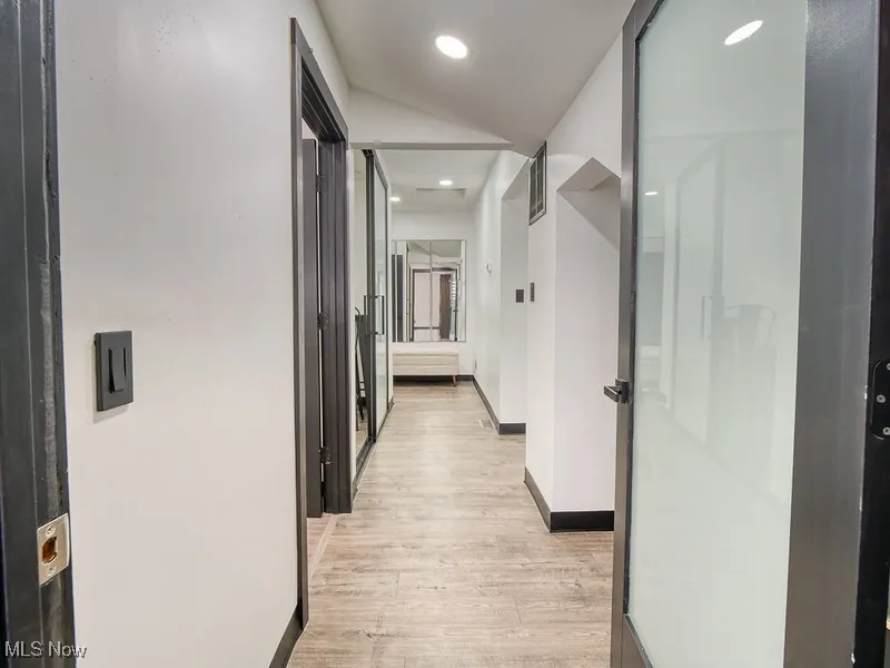Hall featuring light wood-style floors, recessed lighting, and vaulted ceiling