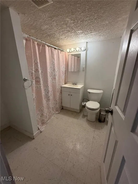 Full bath featuring light flooring, vanity, and a shower stall