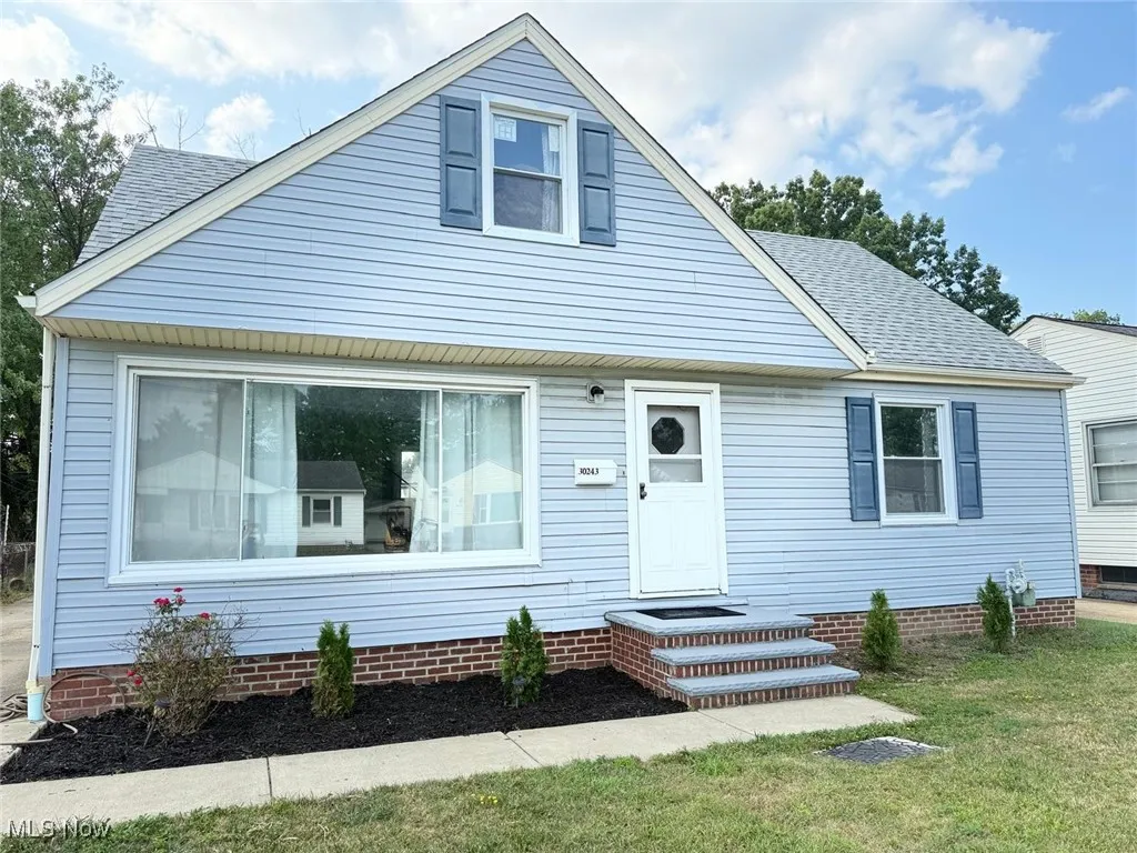 View of front of home with a shingled roof and a front yard
