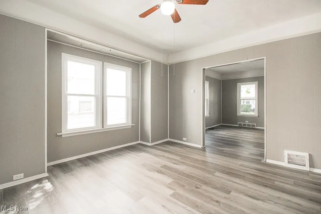 Unfurnished room with ceiling fan and light wood-type flooring