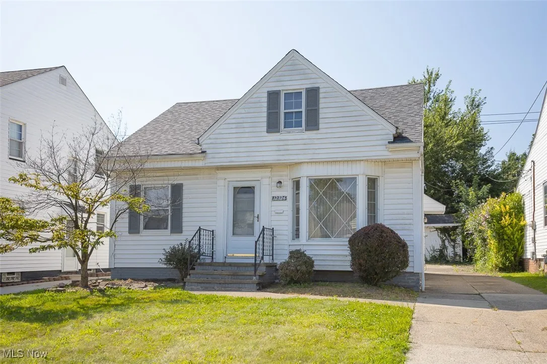 Bungalow featuring roof with shingles and a front yard