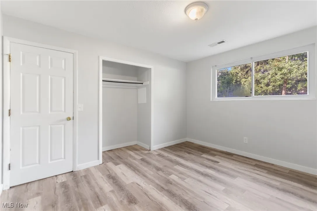 Unfurnished bedroom with a closet and light wood-style flooring