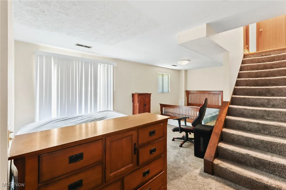Home office featuring light carpet and a textured ceiling