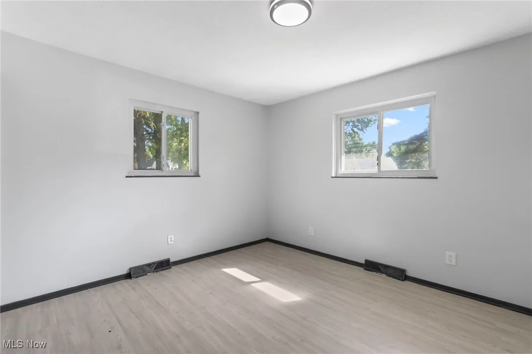 Unfurnished room with light wood-style floors and healthy amount of natural light