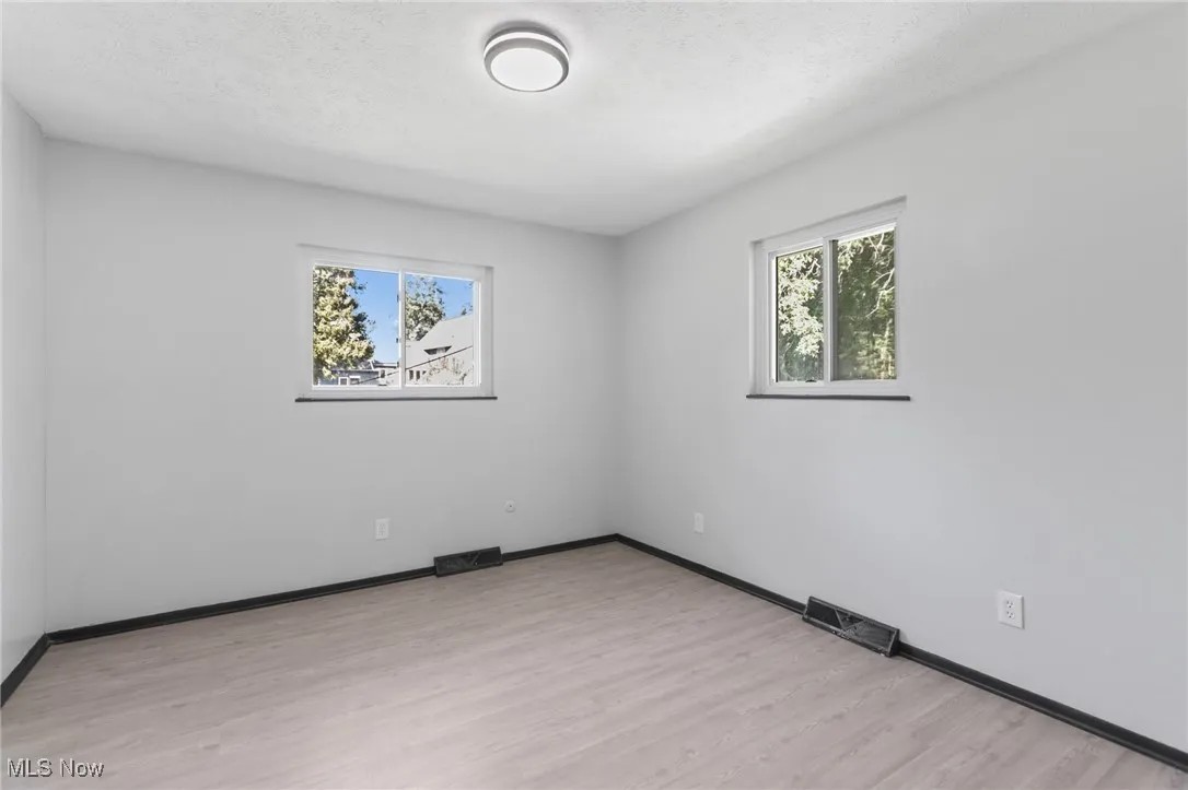 Spare room featuring light wood finished floors and a textured ceiling