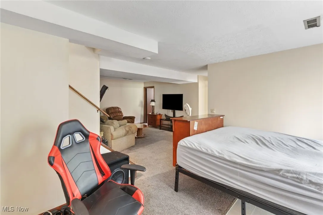 Bedroom featuring light carpet and a textured ceiling