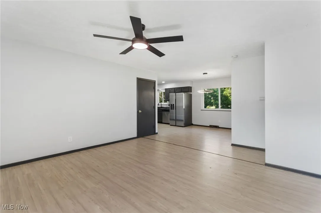 Empty room with light wood-style flooring and ceiling fan