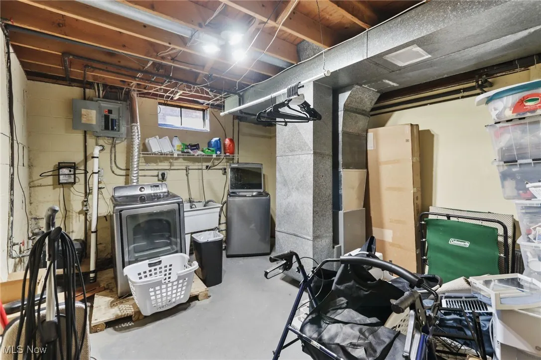 Below grade area featuring heating unit, washing machine and clothes dryer, and electric panel