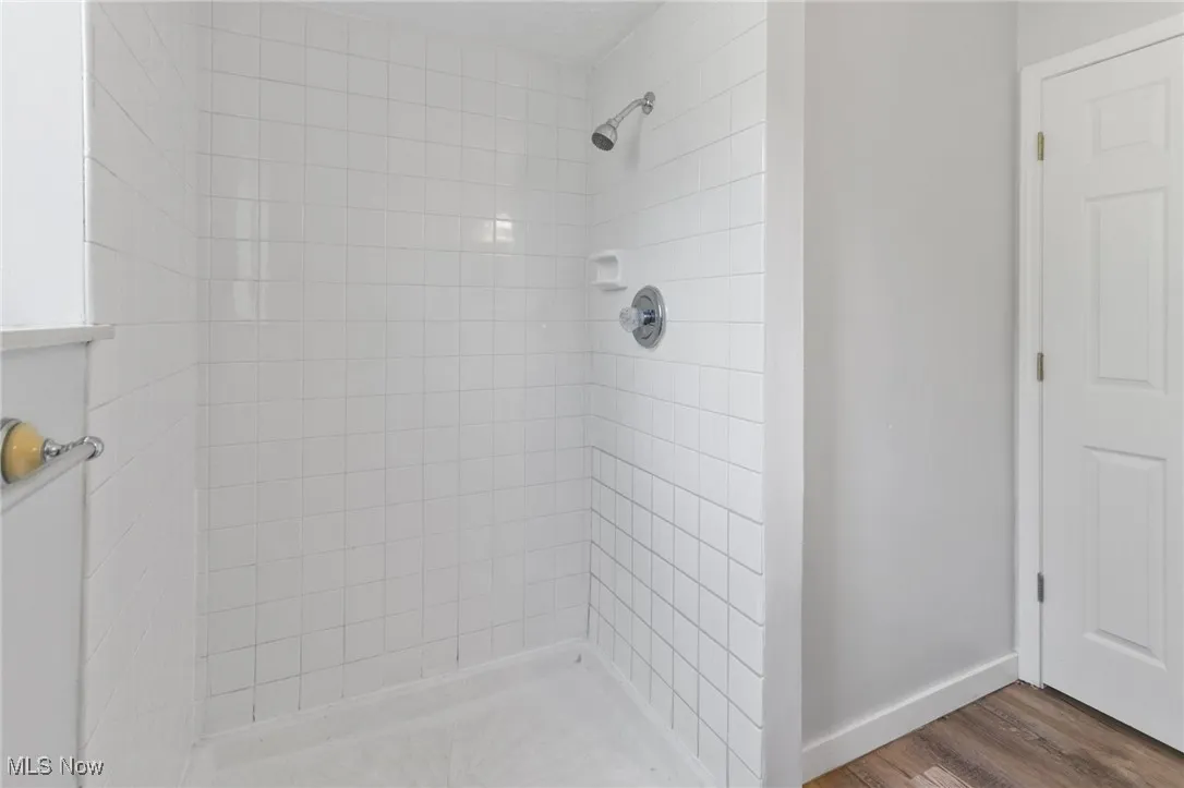 Bathroom featuring a stall shower and wood finished floors