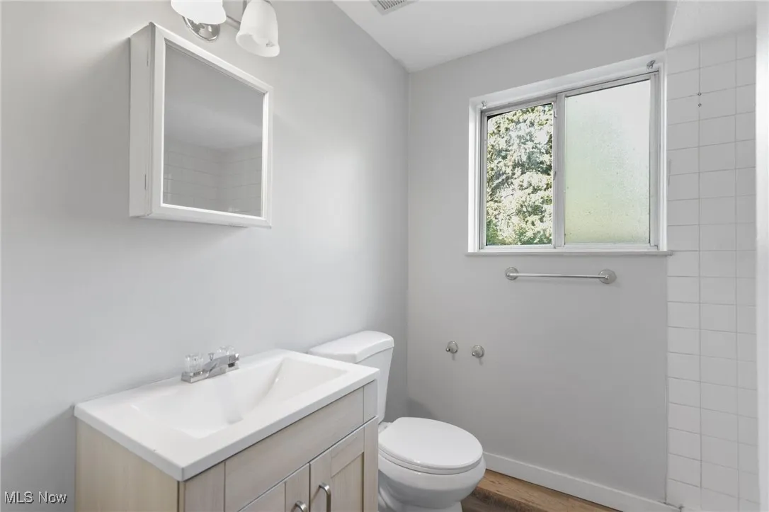 Full bath with vanity and wood finished floors