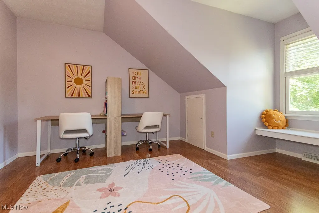 Office with wood finished floors and vaulted ceiling