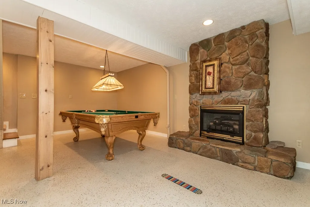 Rec room featuring a stone fireplace, billiards, recessed lighting, and a textured ceiling