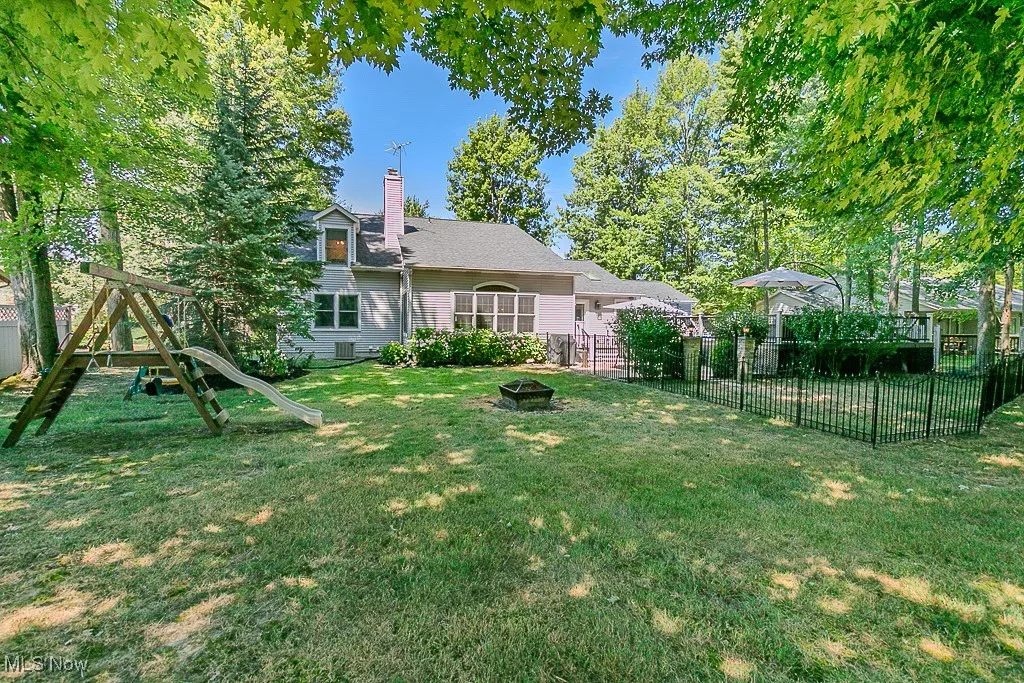 View of yard with a playground and a fire pit