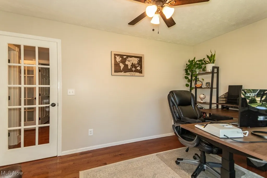 Home office with wood finished floors and a ceiling fan
