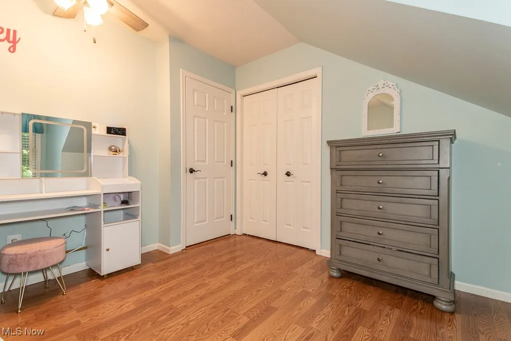 Office space featuring light wood-style floors, a ceiling fan, and vaulted ceiling