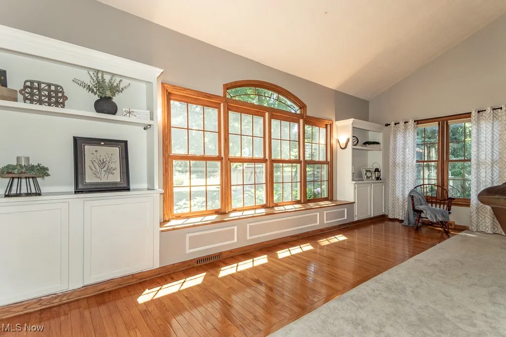 Doorway with hardwood / wood-style flooring and high vaulted ceiling