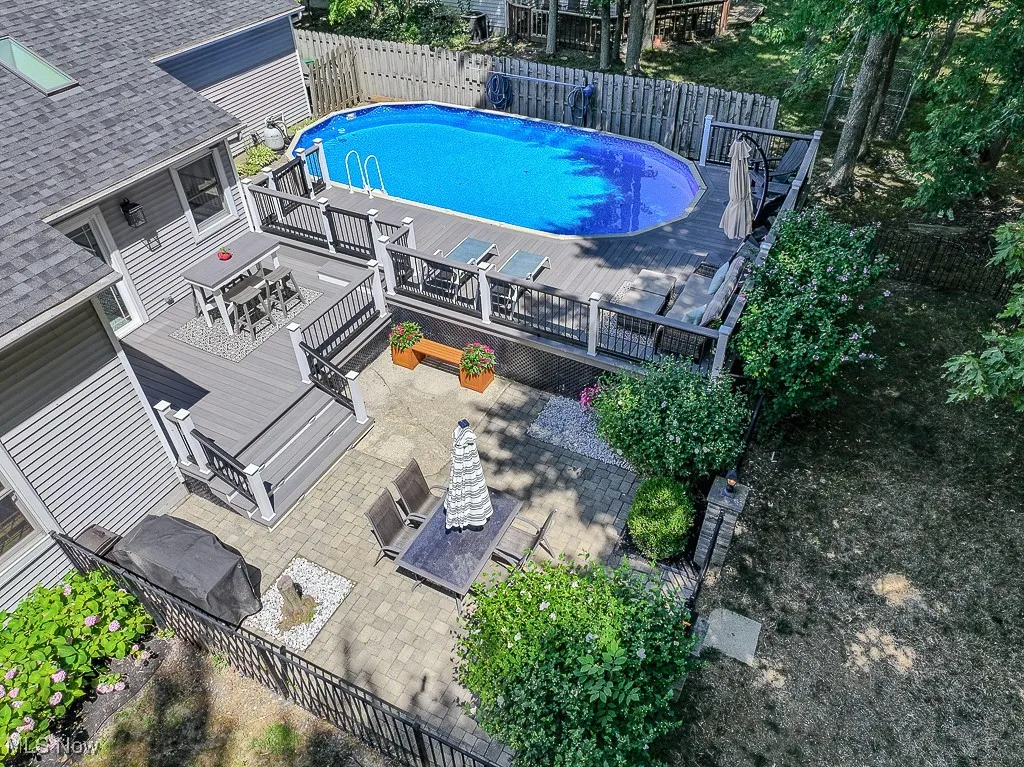 View of swimming pool featuring a patio, a deck, a fenced backyard, and outdoor dining area
