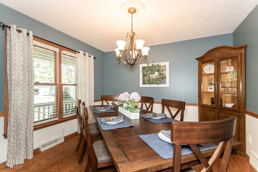 Dining area with wood finished floors and a chandelier