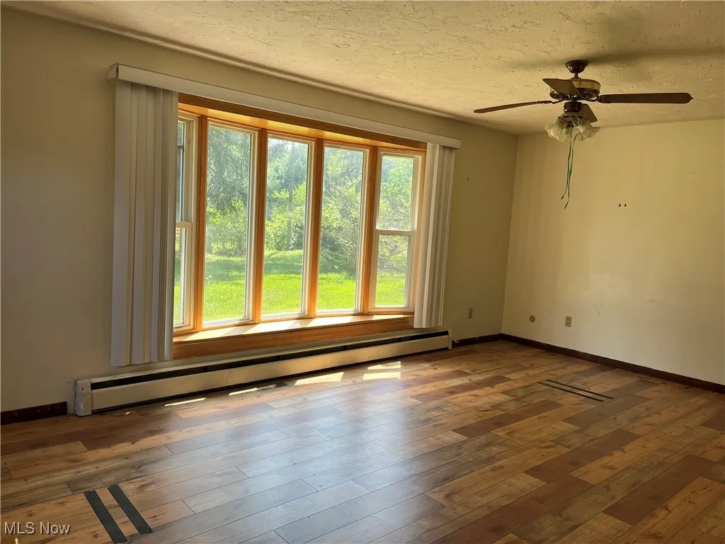 Master bedroom has bowed window, laminate flooring, ceiling fan, blinds and a half bath.
