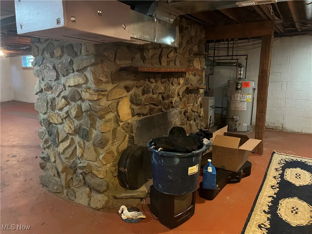 Second side of large masonry stone woodburning fireplace in bsmt.
