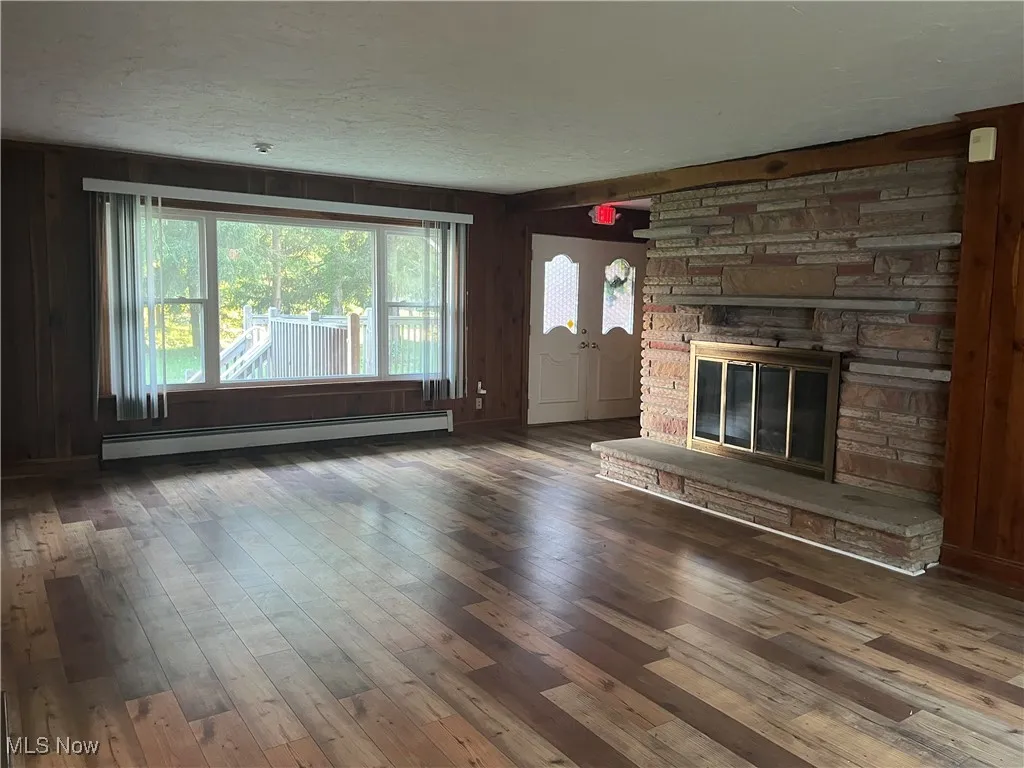 Gorgeous masonry stone fireplace with a raised hearth, laminate flooring and 2 large picture windows in front and back.