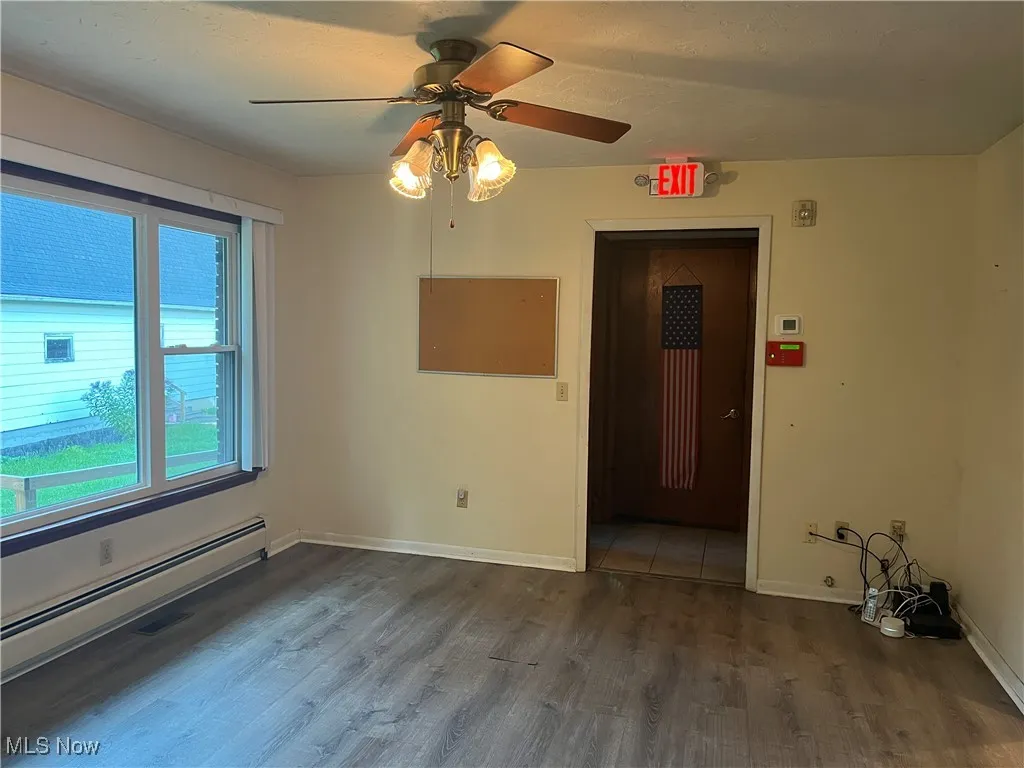 Dining in main house has a large picture window, laminate flooring, and ceiling fan.