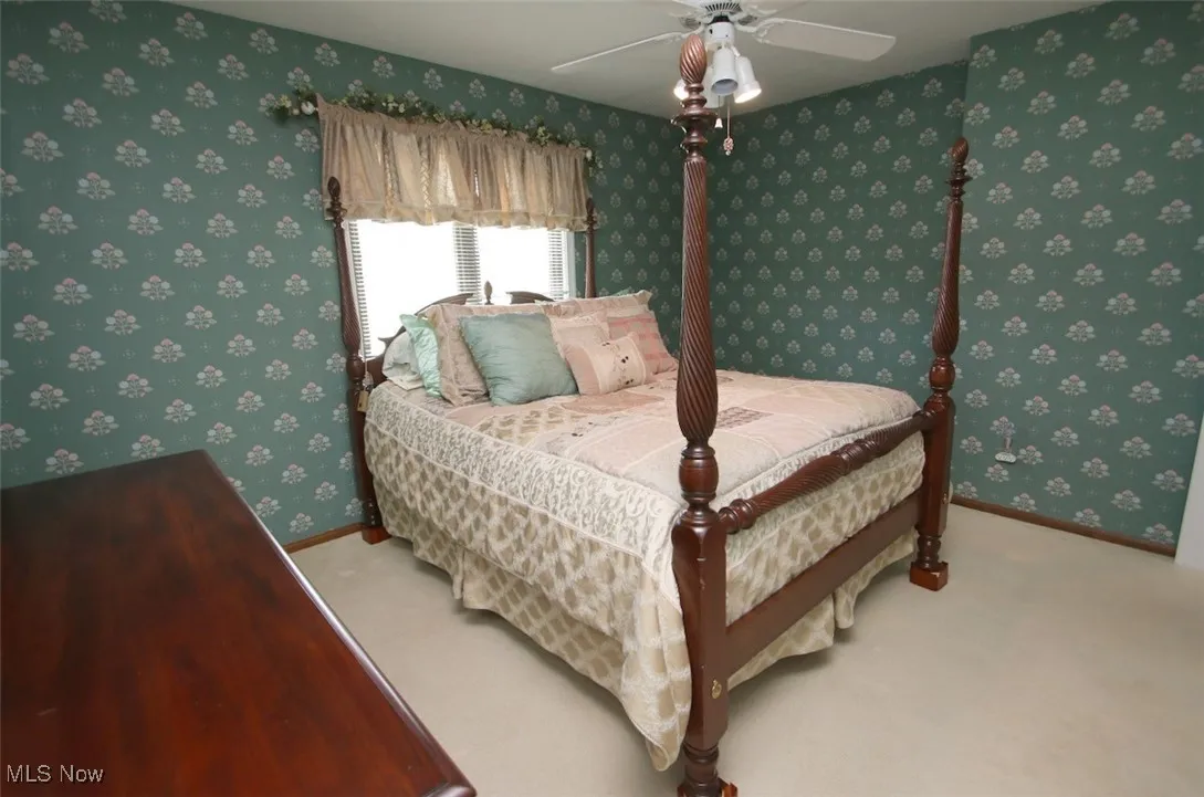 Carpeted bedroom with wallpapered walls and ceiling fan with access to Attic Area